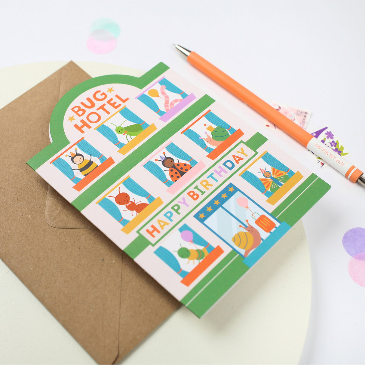 Children's birthday card with cartoon insecrts and a pen on a white background