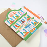 Children's birthday card with cartoon insecrts and a pen on a white background