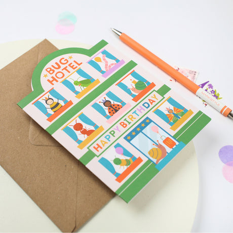 Children's birthday card with cartoon insecrts and a pen on a white background