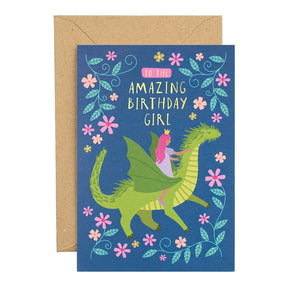 A birthday card with a kraft envelope, illustration of a green dragon and a princess riding it, surrounded by pink flowers and blue leaves on a dark blue background.