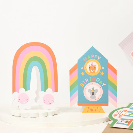 Colourful birthday card with rainbow and rocket design and animal illustrations on a white background