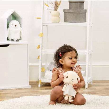 Child holding a plush harry potter dobby soft toy in a room with shelves and decor