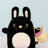Black and white bunny soft toy holding a basket