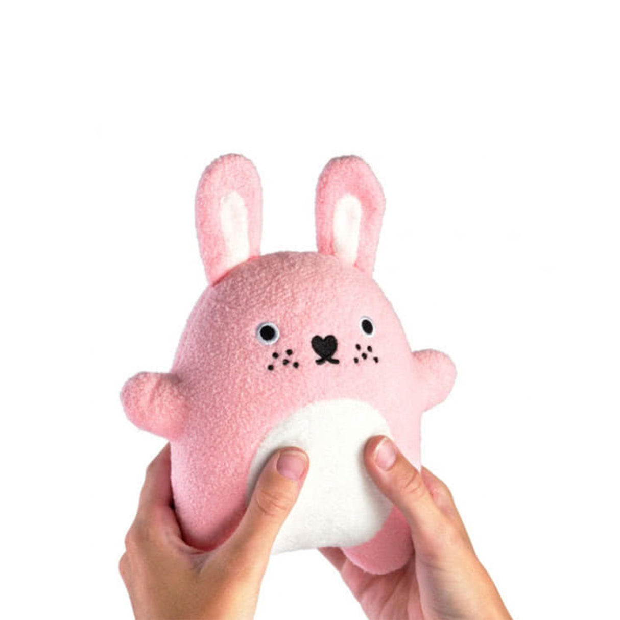 Pink soft toy rabbit with a white belly held by a hand on a white background