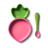 Pink Raddish toddler plate with green top and matching pink spoon on a white background