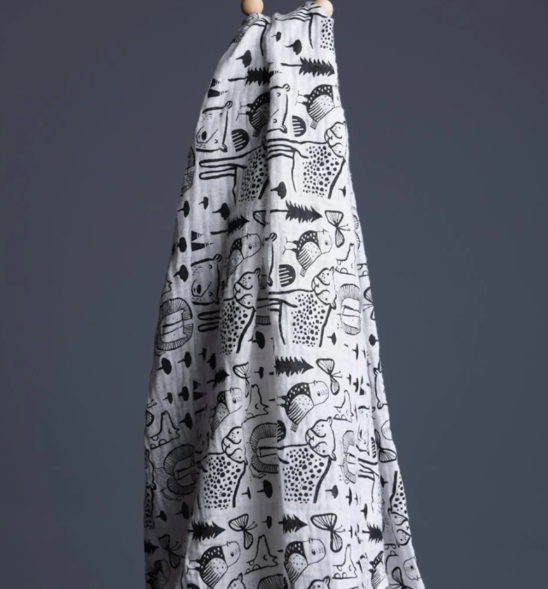 Organic Muslin Swaddle Wild Animals from  wee Gallery hanging with a dark grey background