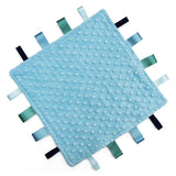 A square baby taggy comforter with a light blue textured minky fabric and ribbon tabs in shades of blue, green, and black on a white background.