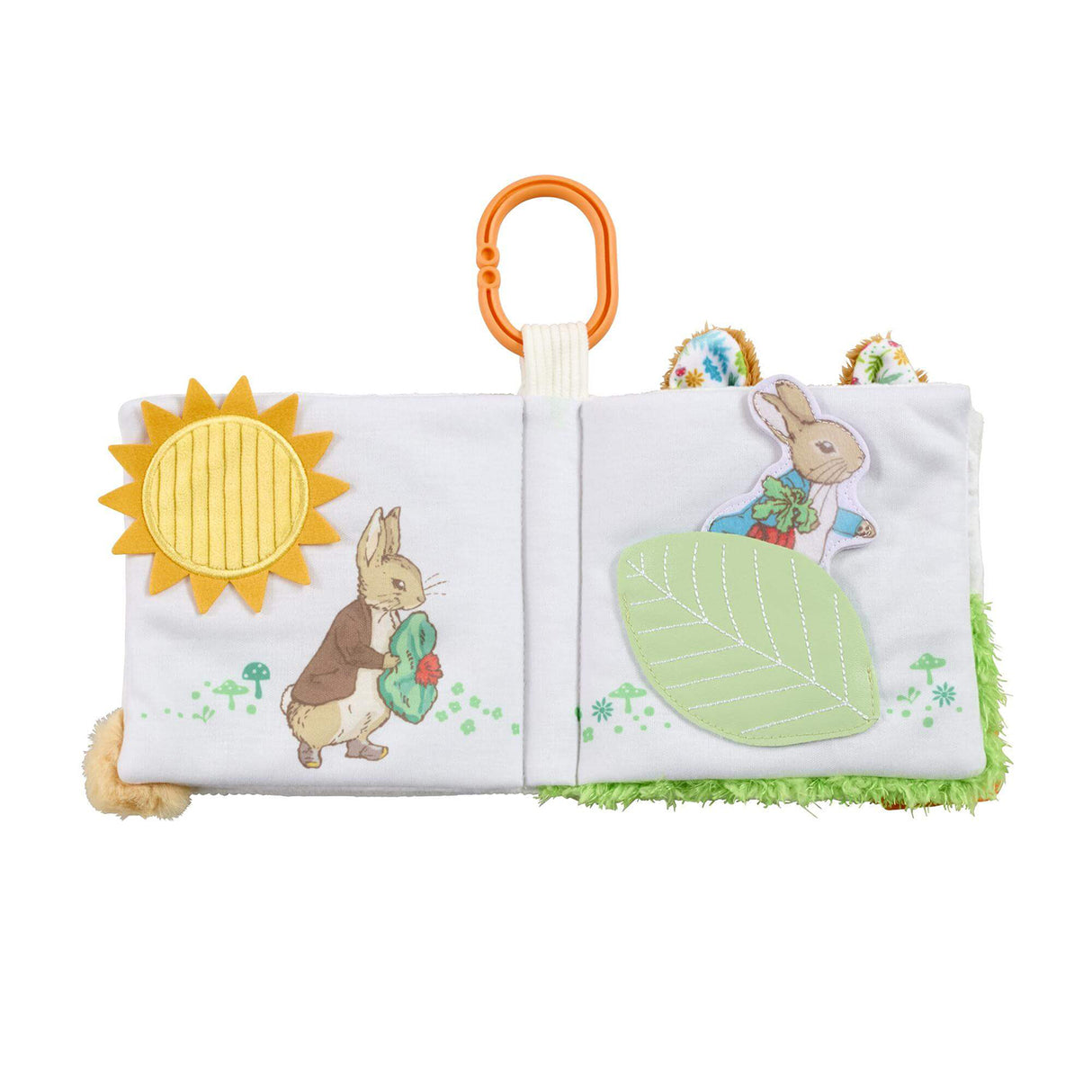 Peter Rabbit fold out activity book open showing Mr McGregor and Peter Rabbit pages with yellow sun teether, green leaf crinkle panel and textured grass edge