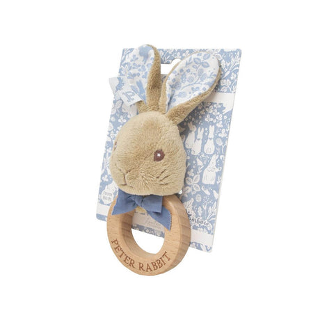 Plush rabbit teething ring with wooden ring on a floral patterned blanket