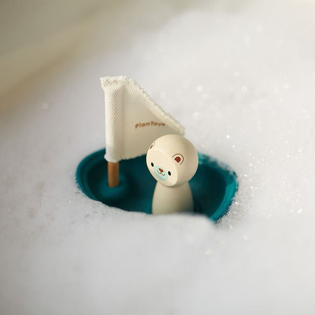 Toy sailboat with a bear figure on a bubble background