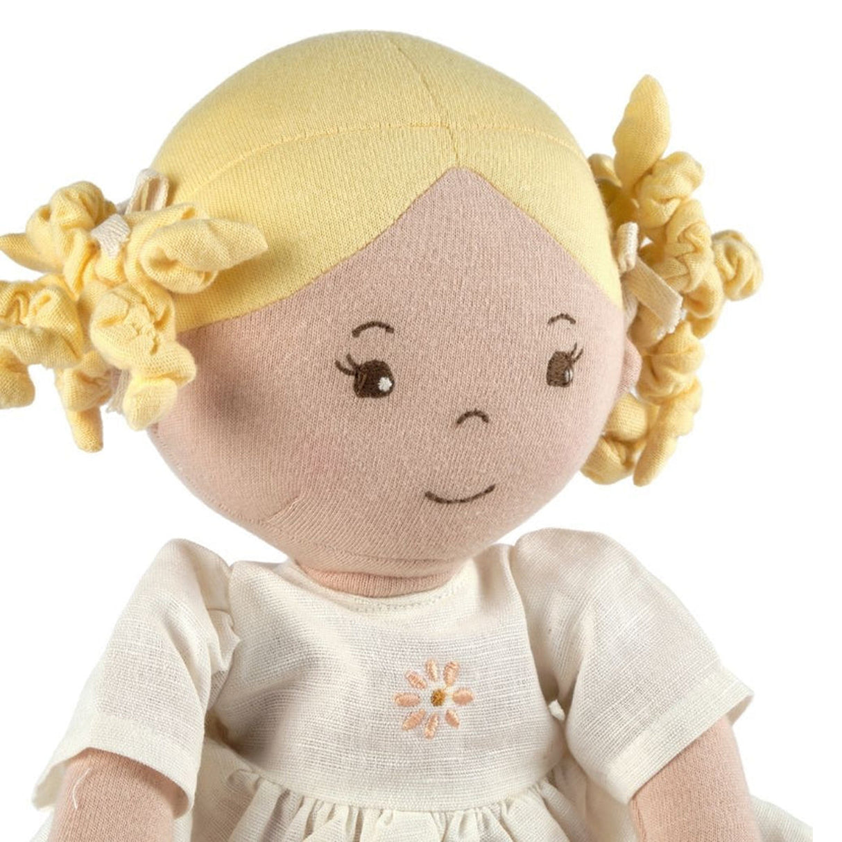 Toy doll with blonde hair and a white dress on a white background