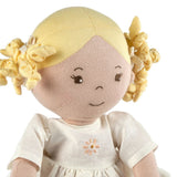 Toy doll with blonde hair and a white dress on a white background