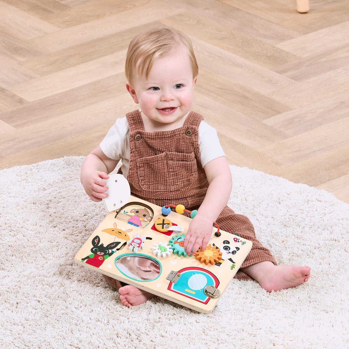 Child playing with a wooden Bing puzzle toy on a carpeted floor.