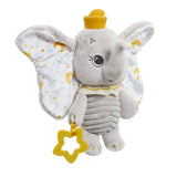 Disney Dumbo My First Soft Toy by Rainbow Designs, grey elephant plush with large fabric ears printed with gold moons and stars, yellow hat, ribbed body, and yellow star-shaped teether, on white background.