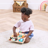 Child playing with a wooden Bing puzzle on a rug in a room with toys and a rainbow decoration.