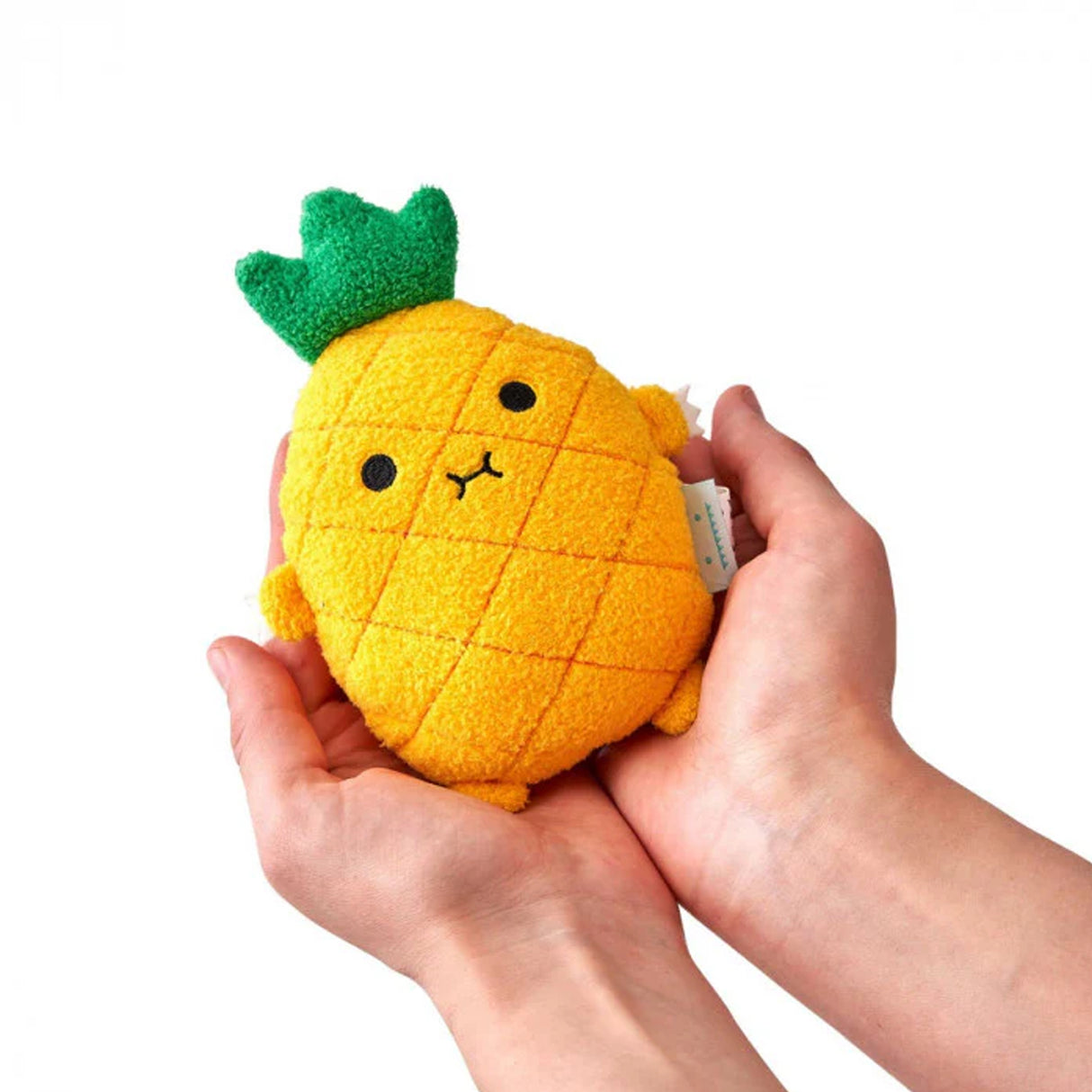 Plush pineapple toy held in hands against a white background
