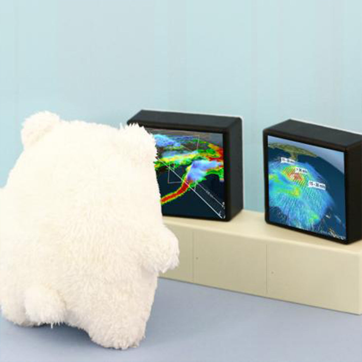 White polar bear teddy looking at two small screens displaying weather maps on a light blue background.