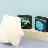 White polar bear teddy looking at two small screens displaying weather maps on a light blue background.