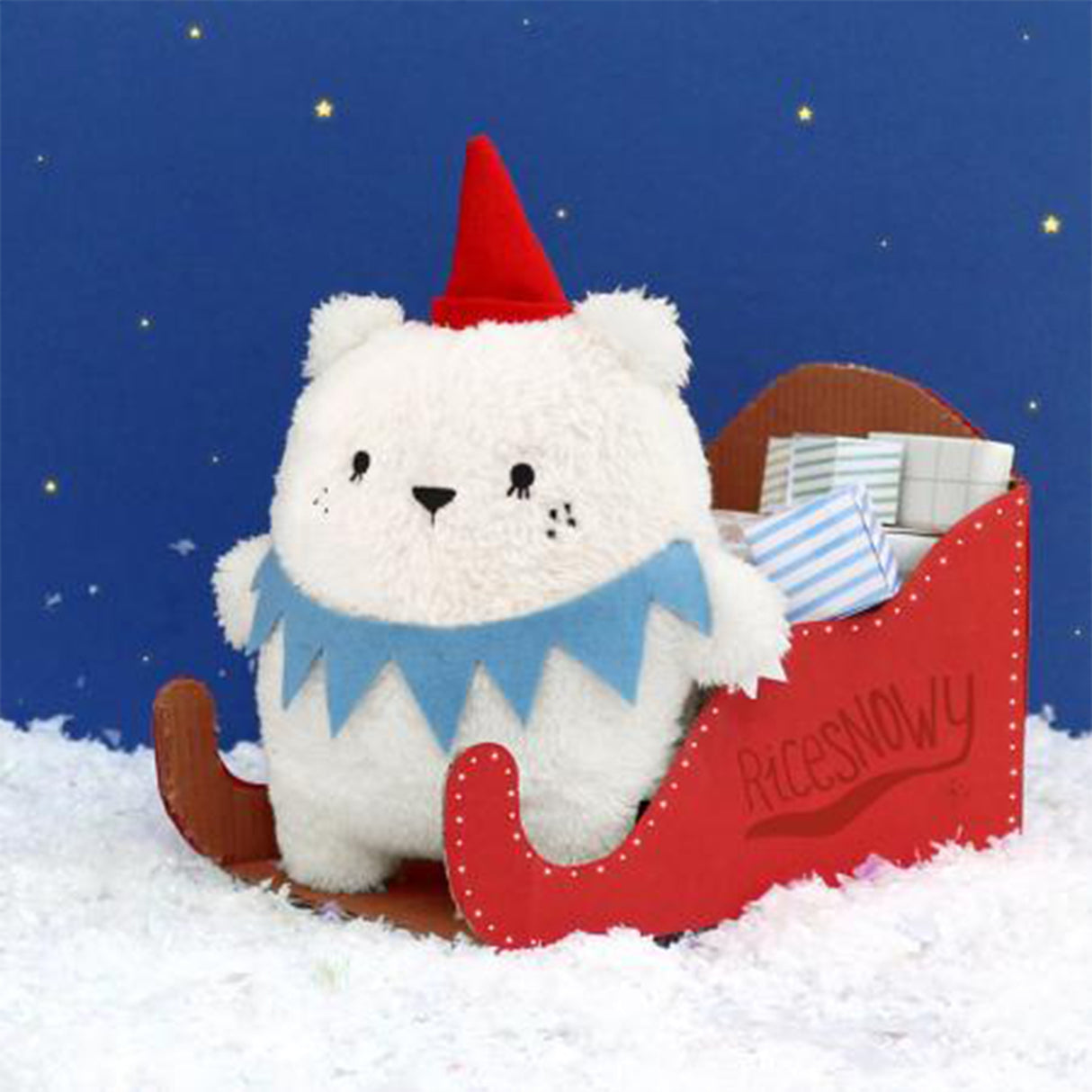 Ricecube polar bear soft toy on a red sleigh and blue stary background