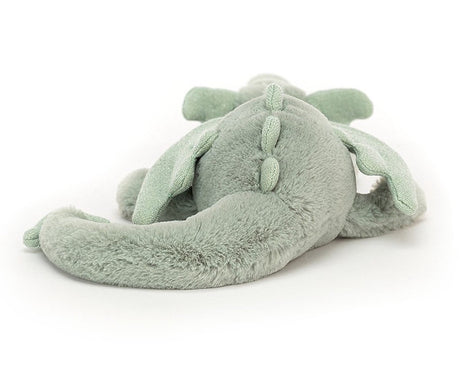 A soft toy depicting a sage green dragon with soft fur, sparkly wings, and a long tail.