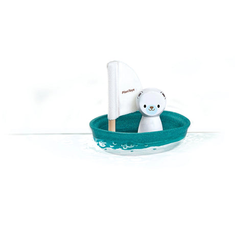 Toy boat with a polar bear figure and sail on a white background