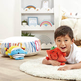 Boy lying on a rug smiling and hugging Mr Strong plush toy by Rainbow Designs

