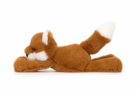 A plush toy representing a dark orange fox with fluffy cream ears and a tail, lying down on a plain background.