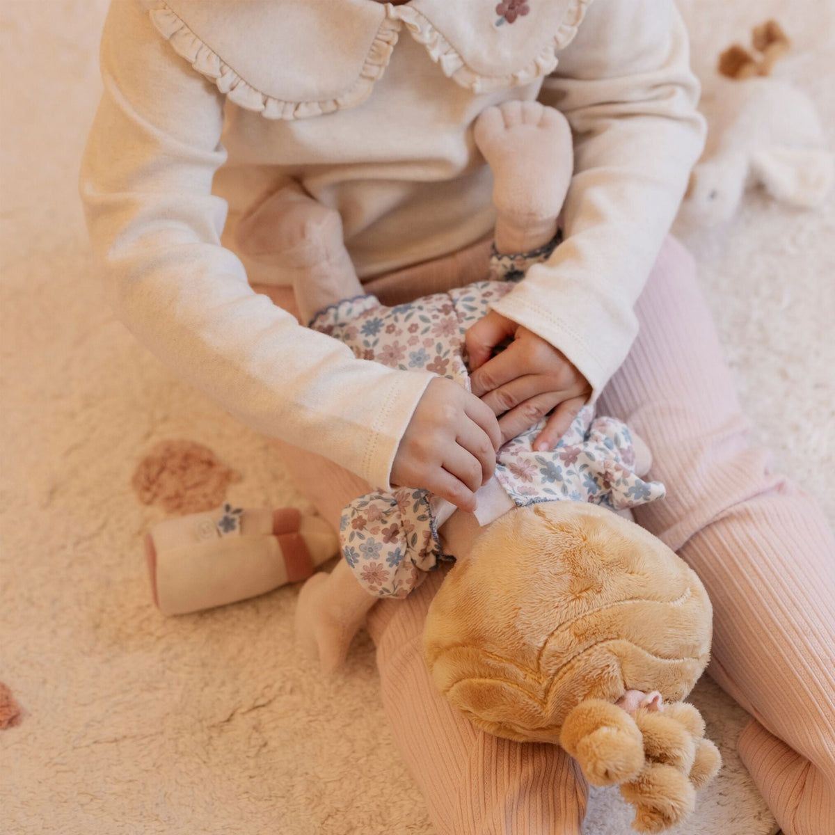 A close-up lifestyle shot of a child playing with baby soft doll Julia