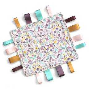 Fabric Baby taggy blanket with colourful ribbons on a white background
