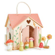 The house is adorned on every side with vibrant wildflower decorations, and two cleverly placed windows allow flower stems to seemingly grow right through the walls, creating a whimsical woodland meadow effect.