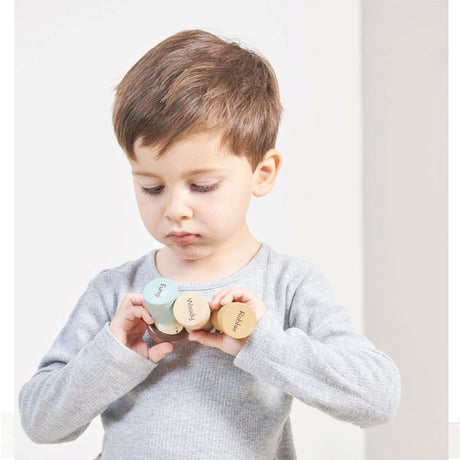 Child holding colorful wooden heart-shaped blocks against a white background