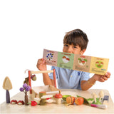 Child holding a educational leaflet with a wooden play set Wild Wood Foraging Trug 