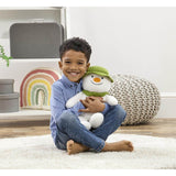 Child holding a plush snowman toy in a room with decorative elements.