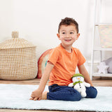 Child sitting on a white rug with a snowman toy, wearing an orange shirt and blue jeans.