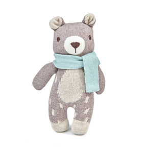 Knitted teddy bear with a light blue scarf on a white background