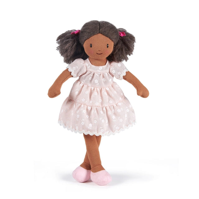 Doll with brown hair and dark skin wearing a pink frilly dress with white flowers on a white background