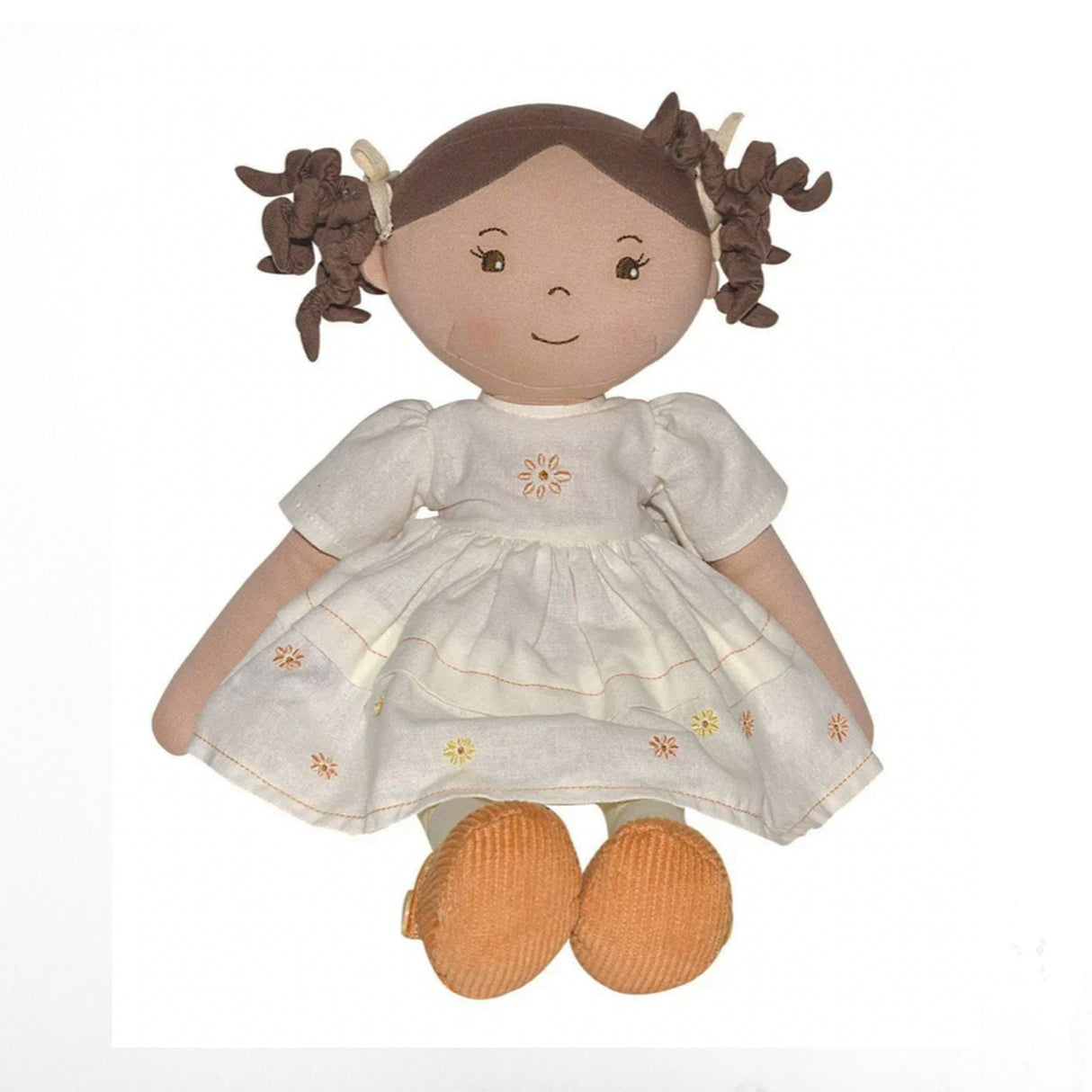 Stuffed doll with brown hair in pigtails wearing a white dress with floral embroidery on a white background