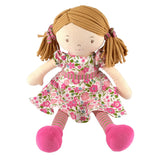 Soft rag doll with pigtails wearing a pink and green floral dress and matching tights and hair ties sitting down