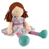 Soft rag doll with brown hair with pigtails wearing a floral pink and turquoise dress, stripey tights and turquoise shoes