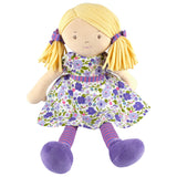 Toy doll with blonde hair, floral dress, and purple shoes on a white background