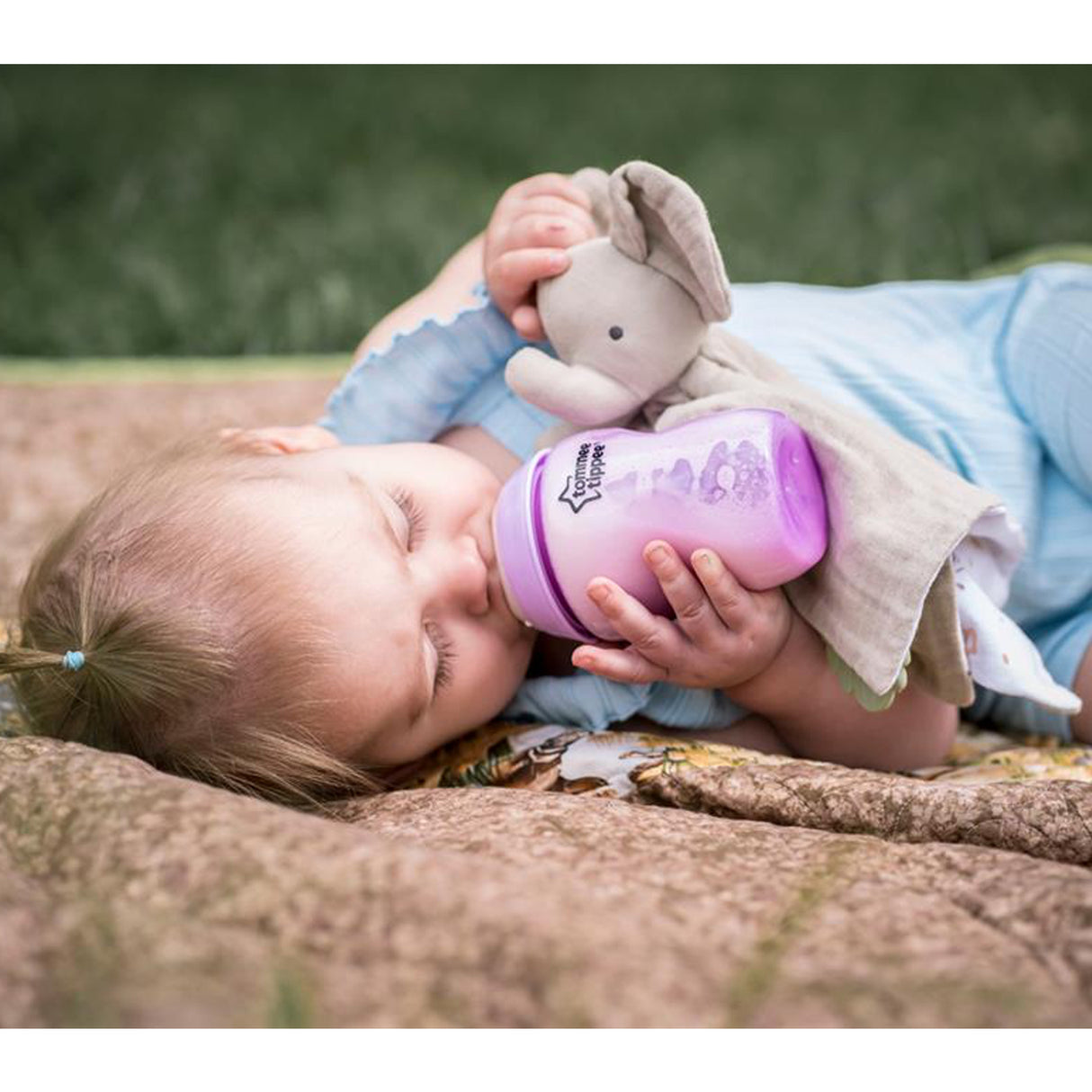 Baby lying down with a elephant muslin comforter