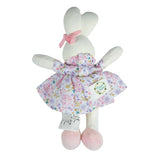 White plush bunny toy with a floral dress on a white background