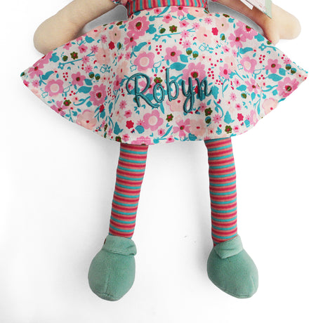Personalised rag doll toy wearing a pink and turquoise dress, stripey tights and turquoise shoes. 