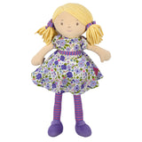 Soft rag doll with blonde hair, purple and green floral dress, and striped leggings on a white background