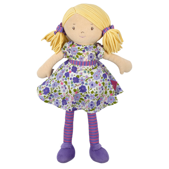 Soft rag doll with blonde hair, purple and green floral dress, and striped leggings on a white background