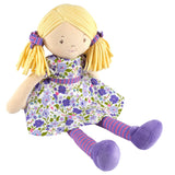 Soft rag doll with blonde hair, purple and green floral dress, and striped leggings on a white background