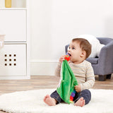 Child playing with The Very Hungry caterpillar Green comfort blanket with colorful rainbow edges and  tags in a home setting
