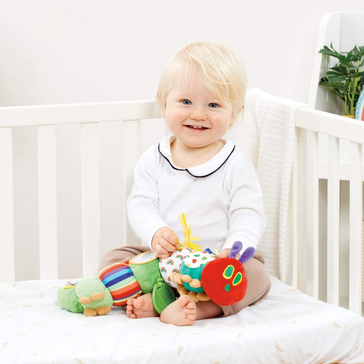 Baby playing with Colorful Very Hungry caterpillar shaped baby toy with various textures and mirrors