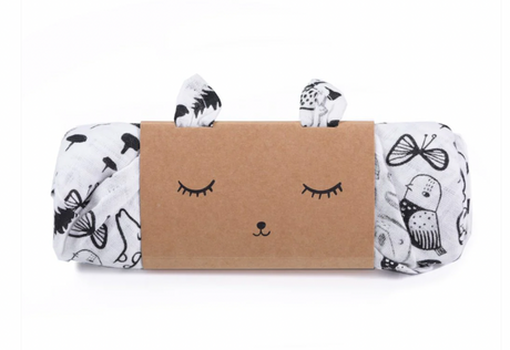 A organic Muslin Swaddle with Wild Animals package with a face