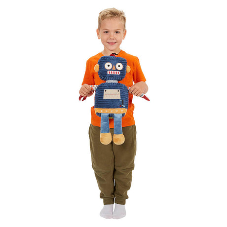 child in orange top holding a dark blue robot toy with a striped shirt and brown feet, made of soft textiles.